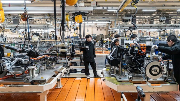 Workers at a Chinese factory during a slowdown as manufacturing activity contracts