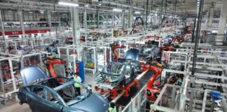 Dozens of Chinese EV Makers Face Shutdown Risks in 2026 Amid Overcapacity Crisis Modern assembly line in a Chinese electric vehicle factory producing multiple EV models