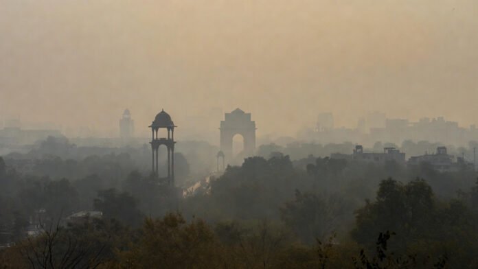 Thick smog shrouding Delhi skyline with India Gate faintly visible on hazy New Year's morning 2026