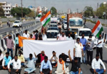 Bharat Bandh on February 12: Transport Disruptions Likely as Trade Unions Call Nationwide Strike Protesters holding banners during Bharat Bandh demonstration with blocked highway in India