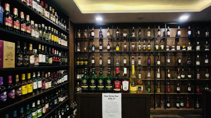 Liquor bottles displayed at a Delhi store as excise license fees increase by 10% for 2026–27
