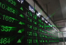 Sensex Jumps 480 Points, Nifty Closes Above 25,700 as Banks, Auto Stocks Rally Digital display board showing Sensex and Nifty gains inside Bombay Stock Exchange