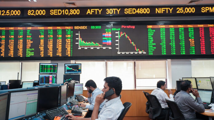 Traders monitoring live Sensex and Nifty market data on digital screens at the Bombay Stock Exchange in Mumbai