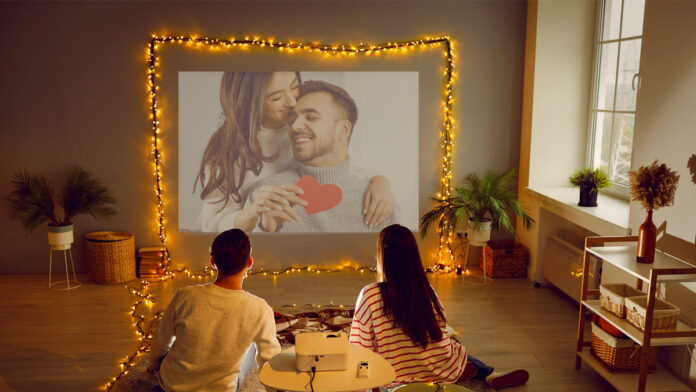 Couple watching movies on OTT platforms during Valentine weekend with Netflix and ZEE5 visible on TV screen.