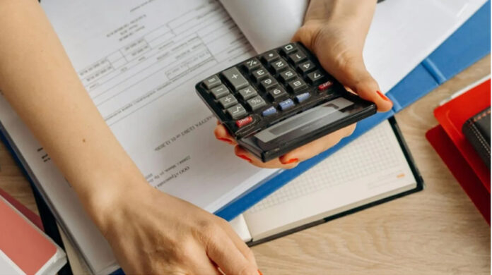 Person using compound interest calculator on laptop to calculate personal loan EMI and interest