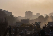 Delhi Pollution Rules 2026: CAQM Tightens Construction Norms, 50,000 AI CCTV Cameras Planned Delhi construction site dust pollution with smog and workers wearing masks