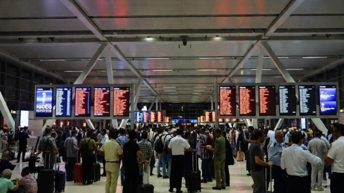 Passengers waiting at Dubai International Airport as Middle East crisis causes flight cancellations and ticket price surge