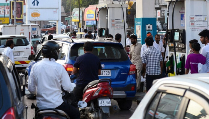 Petrol pump in India showing increased fuel prices with customers refueling vehicles
