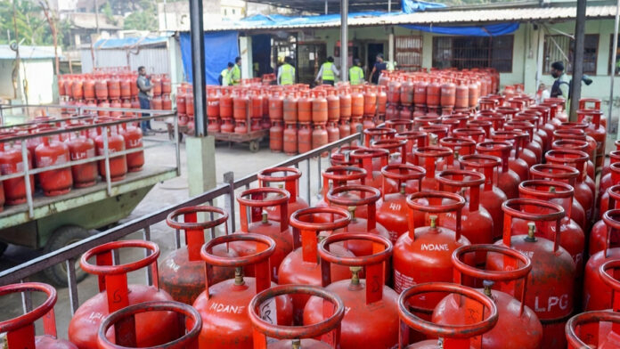 lpg-cylinder-price-hike-ind LPG cylinder price hike in India March 2026 domestic cooking gas cylinder and commercial LPG cylinders stacked at distribution center