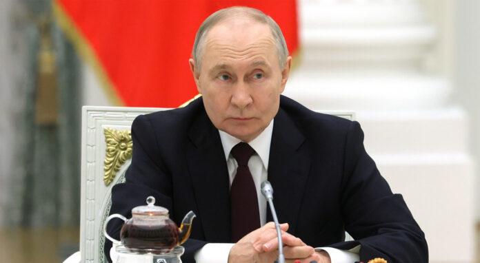 President Vladimir Putin overseeing Russian energy strategy meeting in Moscow March 2026 with charts showing Urals crude premium over Brent and Middle East conflict map