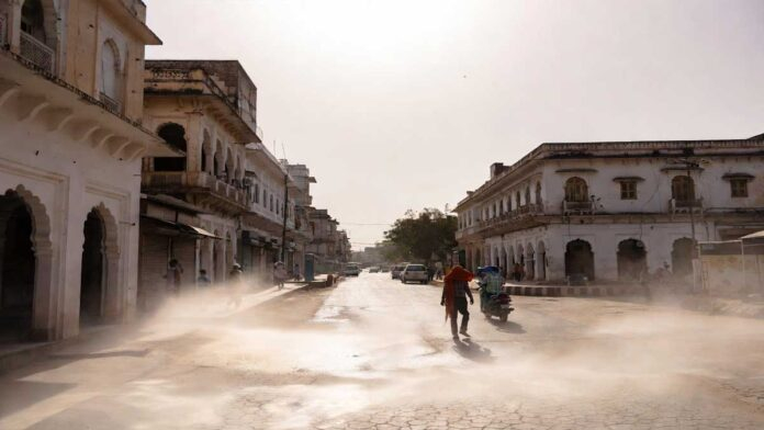 People walking under extreme heatwave conditions in India with high temperature and bright sun