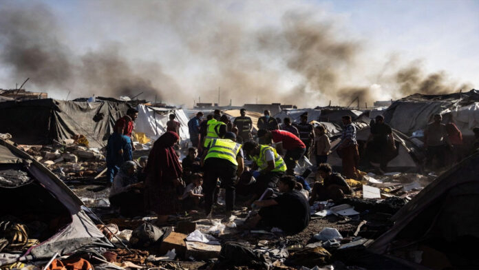 Displaced Palestinian families inspect damage after an Israeli airstrike in southern Gaza