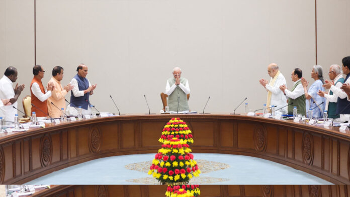 Prime Minister Narendra Modi receives a standing ovation from NDA leaders during a meeting at Bharat Mandapam in New Delhi.